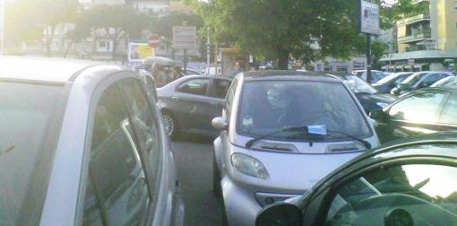 La berlina della Finocchiaro (dietro la Smart) in uscita dal supermercato di piazza Pio XI a Roma, giovedì pomeriggio
